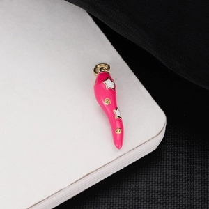 Macro view of pink cornicello pendant with gold trim and white star patterns