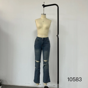 Detail view of dark blue high waist denim jeans featuring stylish distressed knee rips