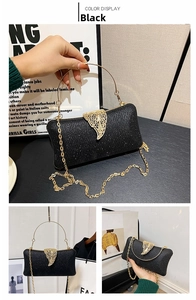 Detail of black glitter clutch bag featuring a gold leaf clasp and round metal handle
