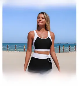 Detail of a black and white two-piece sporty bikini featuring a wrap skirt on a beach