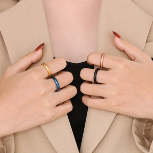 Anelli minimalisti 4mm in acciaio al titanio oro, blu, nero e oro rosa sulle mani della modella