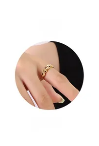 Close-up of golden hollow heart ring band worn on finger with minimalist ring display