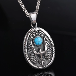 Macro view of vintage eagle pendant with turquoise stone inlay on black mirror