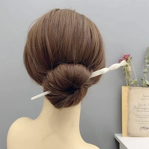 Nahaufnahme einer minimalistischen Haarnadel aus Acetat in einem eleganten Dutt-Haarstil