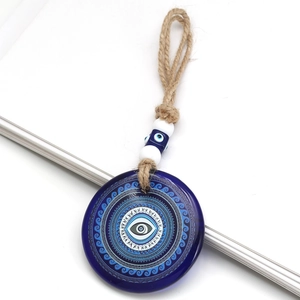 Detailed close-up of blue glass evil eye lucky charm with decorative beads and hemp rope
