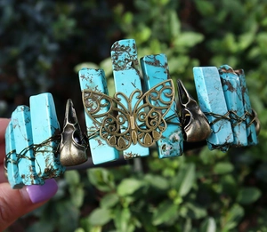 Detail of turquoise stones and bronze raven skull on a handmade Viking crown headband