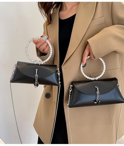 Detail view of the black PU leather handbag with rhinestone-encrusted metal round handle