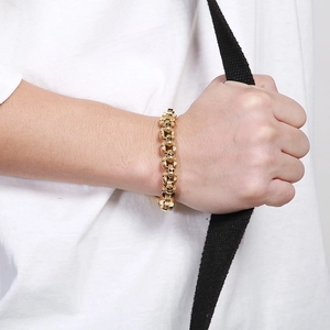 Mens gold skull link bracelet in polished titanium steel with edgy punk aesthetic style