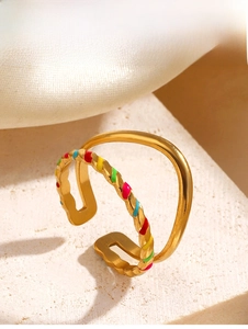 Detail of double-layer gold-plated ring with twisted band and colorful enamel accents