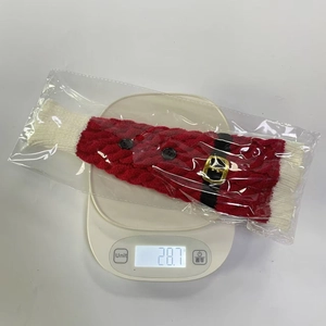 Close-up of a Christmas knitted wine bottle cover with Santa belt design on a digital scale