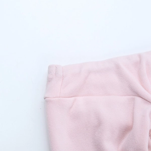 Dettaglio del vestito rosa arricciato che mostra la trama del tessuto e le cuciture