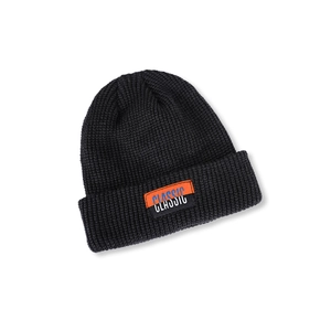 Close-up of black ribbed knit beanie with a colorful CLASSIC decorative label