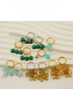 Macro detail of malachite and natural stone charms on 18k gold plated hoop earrings