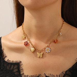Golden stainless steel necklace with daisy, butterfly, and heart charms on a model