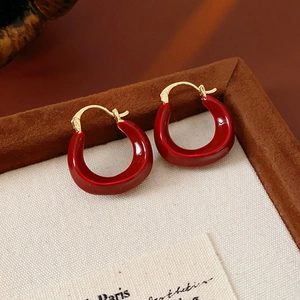 Detail view of red enamel U-shaped earrings on gold plating with elegant vintage style