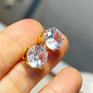 Close-up of gold-plated four-prong earrings with large round clear cubic zirconia stones