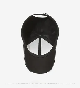 Detail of black baseball cap interior with fashion tape seams and metal buckle