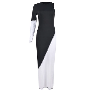 Détail d'une robe longue asymétrique noire et blanche ajustée avec une manche longue