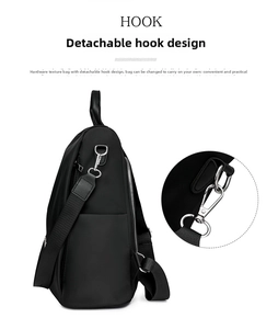 Close-up of detachable silver metal hook and durable nylon strap on black backpack