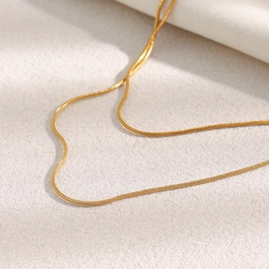 Detail shot of the golden double-layer snake chain necklace with high-polish finish