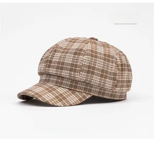 Detail shot of a khaki plaid newsboy cap with classic checked texture and top button