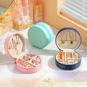 Detail view of round portable jewelry organizers in pink, mint green and navy blue colors