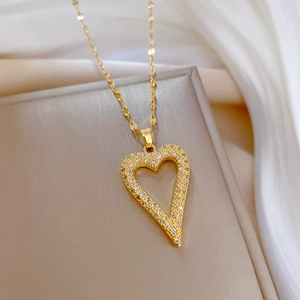 Elegant gold heart pendant necklace with shimmering crystals on a soft silk background