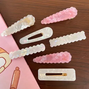 Set of geometric acrylic hair clips with marble texture in pink and pearly white finish