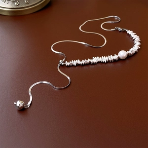 Detailed view of silver snake chain with baroque pearls and metal beads on leather