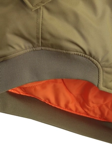 Detail of olive green bomber jacket with orange quilted lining and ribbed hem