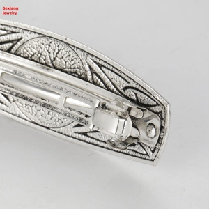 Close-up of vintage silver alloy hair clip featuring ornate geometric floral patterns