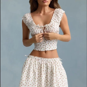Chic two-piece floral set featuring a square neck cropped top and matching skirt in white