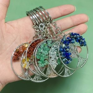 Detail of tree of life keychains with colorful natural stones held in hand