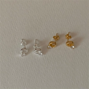 Close-up of minimalist C-shaped 925 silver stud earrings with zircon in gold and silver