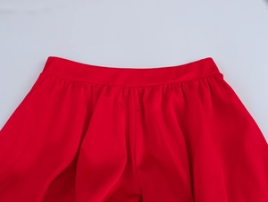 Gros plan sur la taille du short en satin de soie rouge avec d'élégants détails plissés