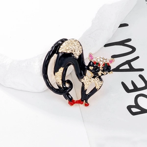 Detail of black enamel cat brooch with gold lines and sparkling white rhinestones