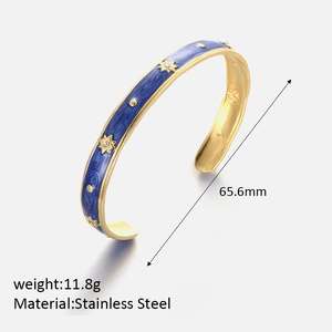 Detail of 65.6mm stainless steel gold plated star bangle with blue enamel and zircon