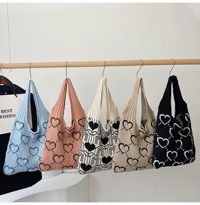 Détail de cinq sacs en tricot à motifs de cœurs avec poignées intégrées en plusieurs couleurs