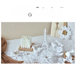 Detailed view of white Christmas tree ornaments set with snowflakes, deer, and tower shapes