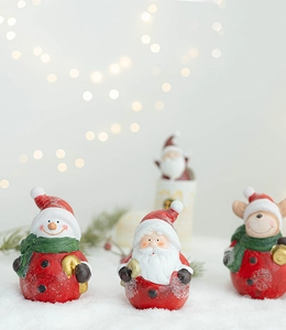 Detailed view of resin Santa, snowman and reindeer figurines with snow texture finish