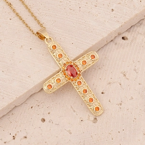 Macro detail of 18K gold-plated cross pendant with micro-pave orange zircon stones