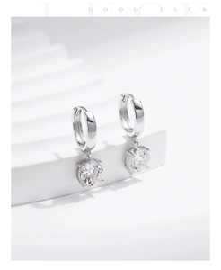 Macro shot of silver drop earrings with faceted round zircon stones and a polished finish