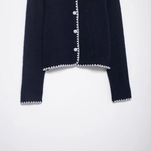 Navy blue knit cardigan with white scalloped contrast trim and round buttons