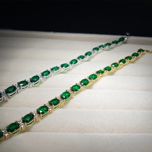 Detailed macro view of gold and silver emerald tennis bracelets with AAA cubic zirconia