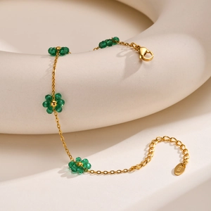 Detail of gold flower bracelet with green crystal beads and lobster clasp closure