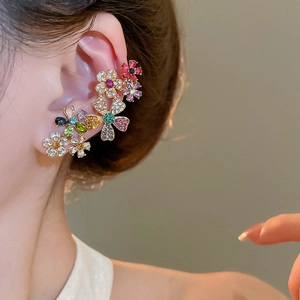 Close-up of model wearing multi-color crystal flower ear cuffs in 18k gold plating