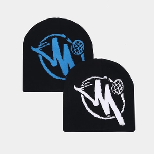 Macro detail of the woven blue and white jacquard pattern on the black knit beanie