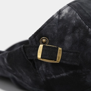 Detail of adjustable metal bronze buckle on retro tie-dye cotton newsboy cap