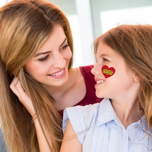 Tatouage cœur temporaire pour fête des mères sur visage d'enfant avec texte Love Mom