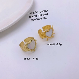 Detailed close-up of 18k gold plated copper heart rings with natural mother of pearl